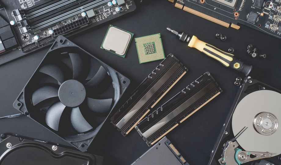 top view of computer parts with harddisk, ram, CPU, graphics card, SSD(solid state drive), motherboard, tools and Fan case on black steel background.