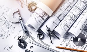 Blueprints and drafting tools including a compass, scale ruler, and pencil, illustrating technical drawing and design processes relevant to careers in drafting and design technology.