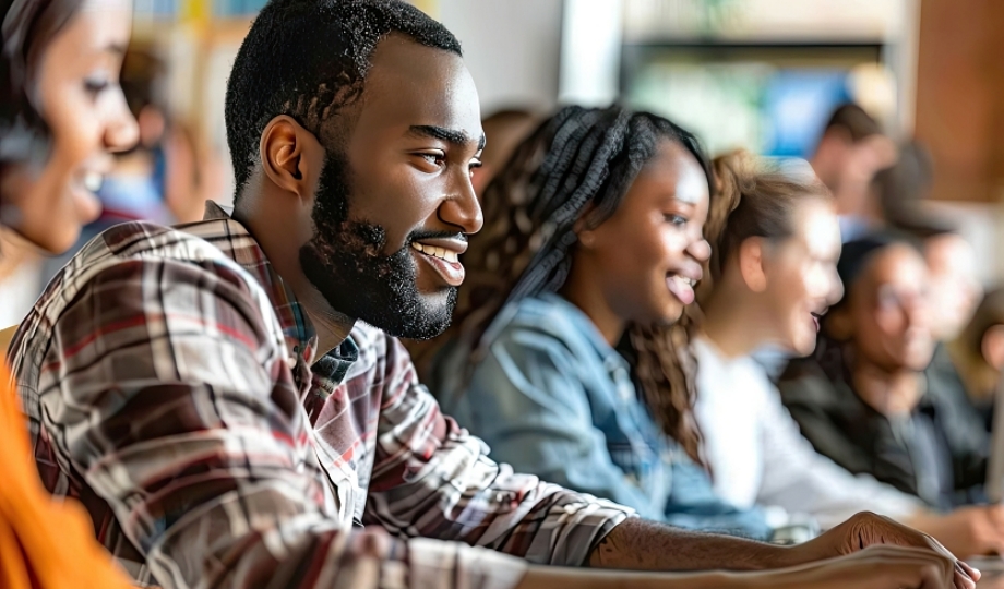 Teacher giving lesson to diverse multiethnic group of students in college room, Teaching new academic skills on a computer.