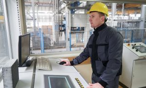 Process Technicians at control room. Portrait of a young technician worker in a factory. The operator monitors the work process from control room