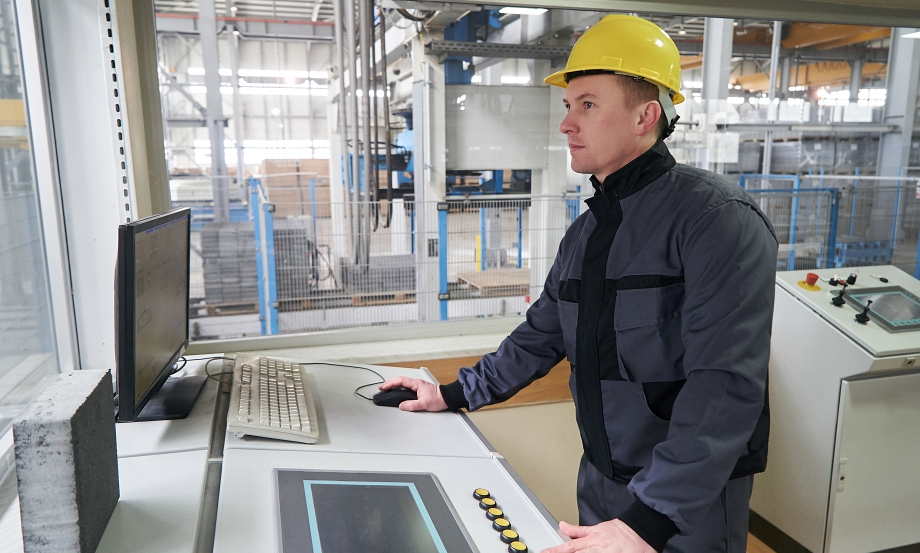 Process Technicians at control room. Portrait of a young technician worker in a factory. The operator monitors the work process from control room
