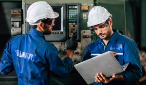 industry engineer team worker operate control heavy machine with computer laptop to help analysis operating problem.