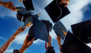 Graduates throwing graduation hats Up in the sky