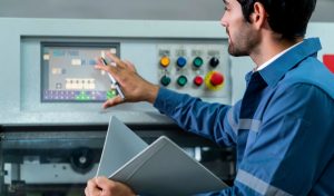 Male Asian caucasian engineer professional having a discussion standing consult at machine in the factory ,two expert coworker brainstorm explaining and solves the process of the cnc operate machine