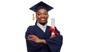 education, graduation and people concept - happy graduate student woman in mortarboard and bachelor gown with diploma over white background