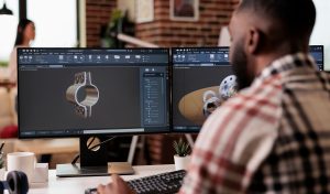 African american developer setting up gears model on manufacturing software, developing engine product for technical industry innovation. Creating turbine design with industrial CAD science.