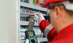 Electricity and electrical maintenance service, Engineer hand holding AC voltmeter checking electric current voltage.
