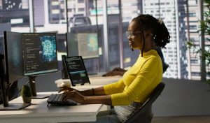 Computer scientist testing AI company software, identifying errors in machine learning tech. African american IT staff member writing artificial intelligence code in programming language, camera A