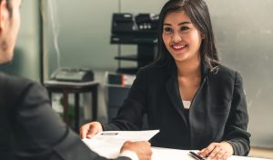 Human resource manager interviewing the male employment candidate in the office room. Happy job interview. Job application, recruitment and labor hiring concept.