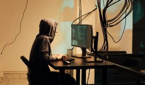 Female hacker committing cyberattack on server firewall, gaining access to steal government information. Young woman planting trojan virus and malware, doing cyberbullying and identity theft.