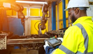Engineer check and control automation robot arms.Robot arms machine in intelligent factory industrial on monitoring system software. Welding robotics and digital manufacturing operation.