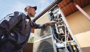 HVAC technician servicing home heating and cooling system.