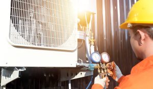 HVAC technician using pressure gauges to service an outdoor condenser unit