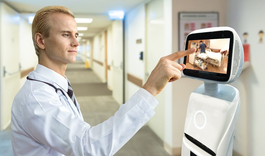 Doctor using a hospital service robot's touchscreen to check on a patient room