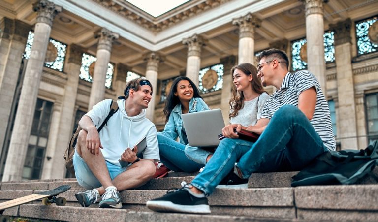 Students on a college campus deciding between trade school or 4-year college